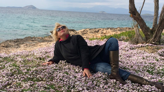 Lying in wild spring violets by the sea on Aegina Island Greece — Mediterranean longevity lifestyle