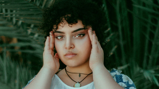 Woman holding temples, confused